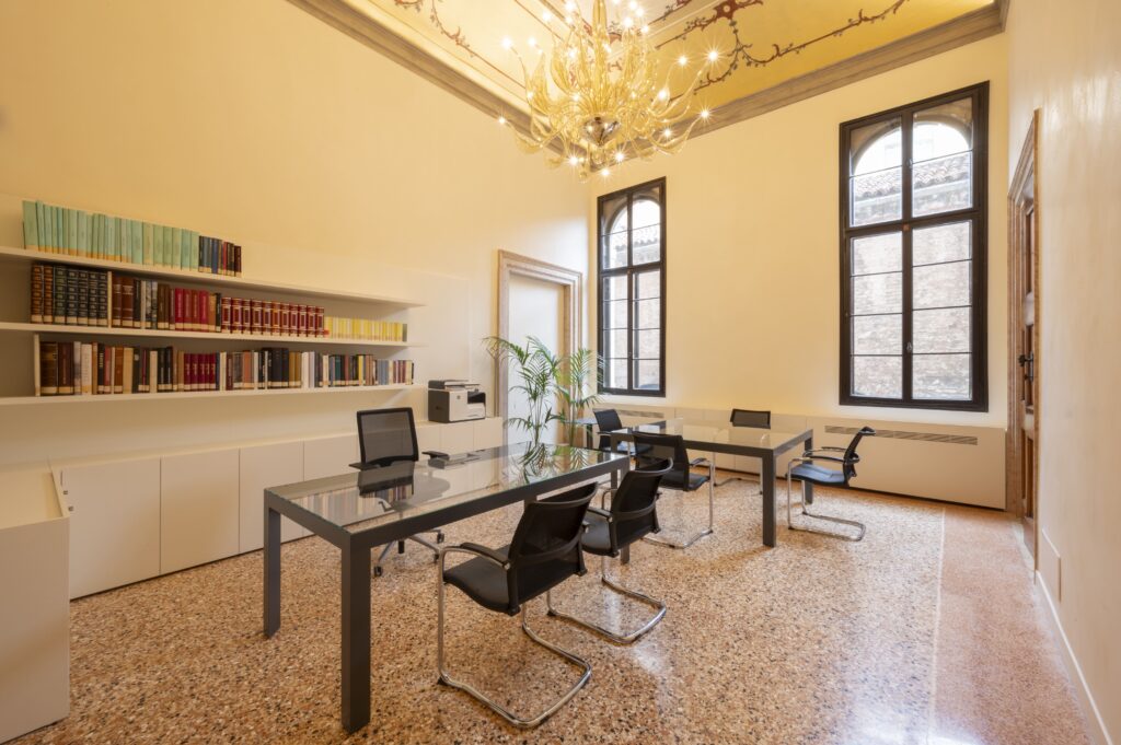 Signorile studio in palazzo storico con scrivanie moderne in vetro